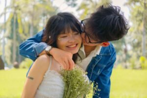 Couple embracing outdoors with a bouquet of flowers